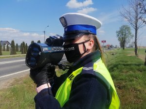 Policjantka ruchu drogowego w trakcie pomiaru prędkości.