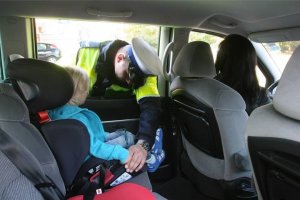 Policjant kontroluje sposób przewożenia dziecka