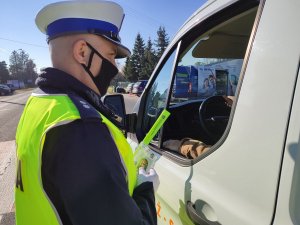 Policjant wręcza zapach samochodowy i odblask kierowcy