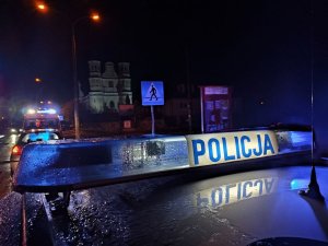 Sygnały świetlne policja. W tle karetka pogotowia, przejście dla pieszych oraz kościół.