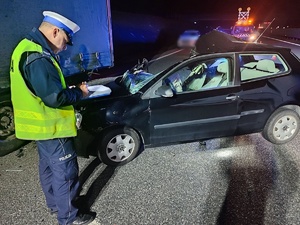 Uszkodzone auto. Policjant wykonuje oględziny