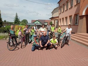 Dzieci z policjantem w trakcie egzaminu praktycznego.