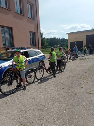 Dzieci z policjantem w trakcie egzaminu praktycznego.