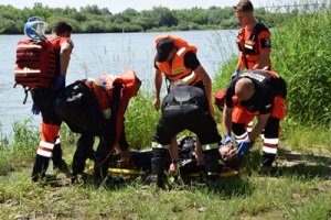 Służby ratunkowe udzielające pomocy osobie poszkodowanej wyciągniętej z wody