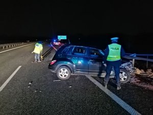 Policjant ruchu drogowego i technik kryminalistyki pracujący na miejscu wypadku