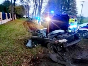 Samochód po zdarzeniu drogowym. Leży na prawym boku. Na miejscu pracują służby.