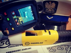 Na zdjęciu widzimy ręczny miernik prędkości, czapkę policjanta WRD oraz alkomat.