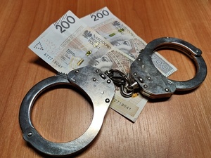 banknoty 200 złotowe i kajdanki w sprawie wręczenia łapówki policji