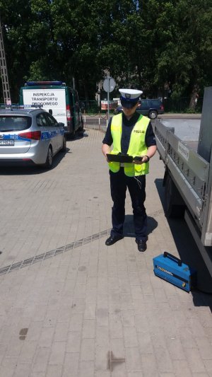 Policjant WRD KPP Żuromin podczas badania emisji spalin w pojeździe