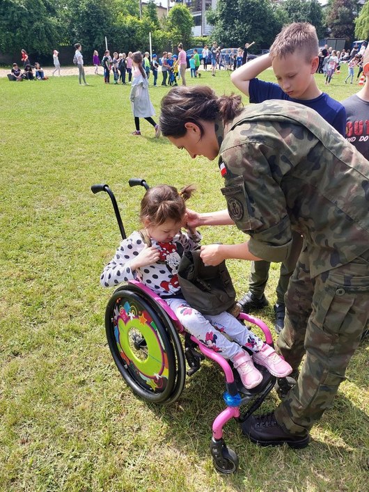 dziewczynka na wózku rozmawia z żołnierzami