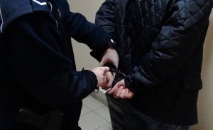 Na zdjęciu policjant zakuwający mężczyznę w kajdanki