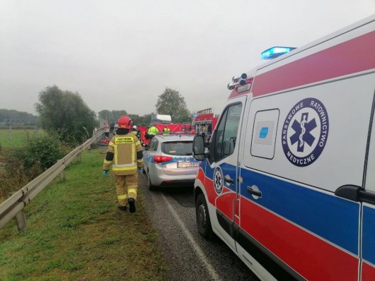 Wypadek w Mszczonowie na ul. Grójeckiej. Na zdjęciu widoczny jest radiowóz policyjny oraz wóz strażacki i idący strażak